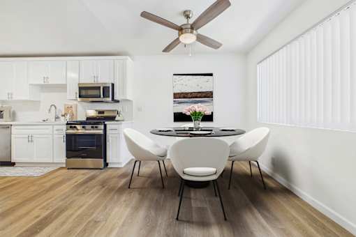 A modern kitchen with a dining table set for four.