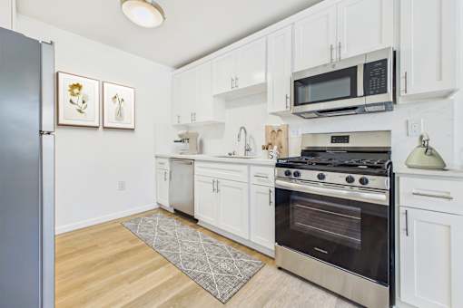 A kitchen with white cabinets and a stainless steel oven.