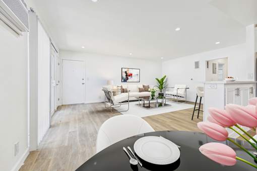 A modern living room with a dining table set for two.