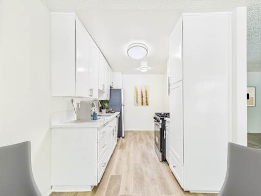 A kitchen with white cabinets and appliances.