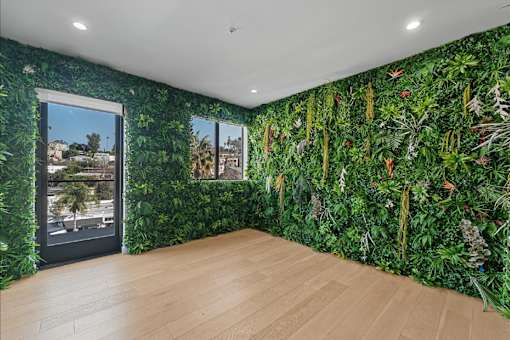 A room with a green wallpaper and a wooden floor.