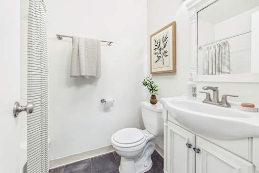 A white toilet sits next to a white sink in a bathroom.