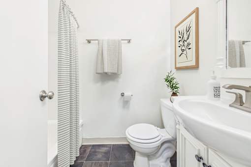 A white toilet sits next to a white sink in a bathroom.