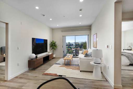 A modern living room with a flat screen TV and a view of the outdoors.
