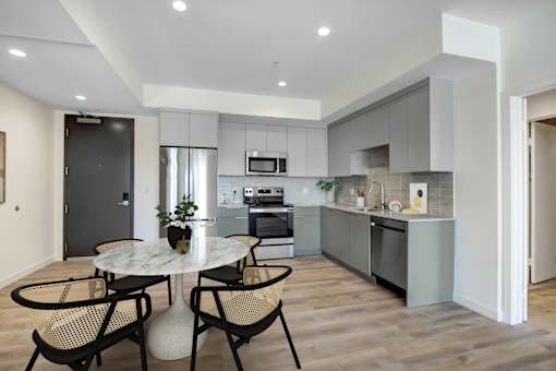 A modern kitchen with a dining table and chairs.