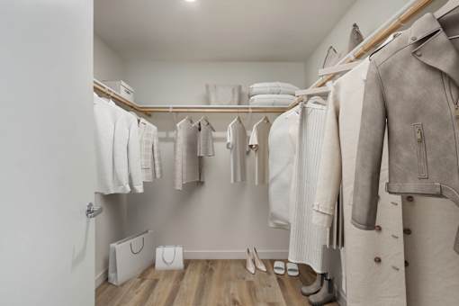 A row of clothes hanging on a rack in a room.
