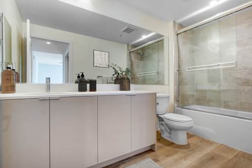 A white toilet sits next to a bathtub in a bathroom.
