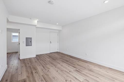 A room with wooden flooring and white walls.