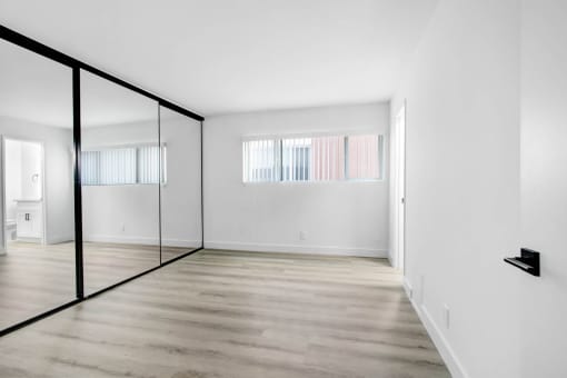 an empty room with white walls and a glass door