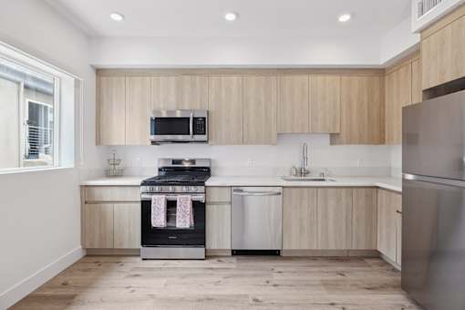 A modern kitchen with wooden cabinets and stainless steel appliances.