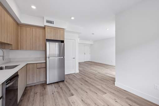 A kitchen with wooden cabinets and a stainless steel refrigerator.