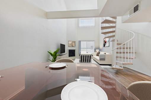A modern dining room with a glass table and chairs.