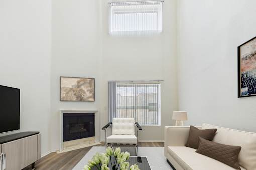A living room with a fireplace, a white couch, and a painting on the wall.