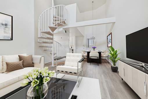 A white living room with a spiral staircase.