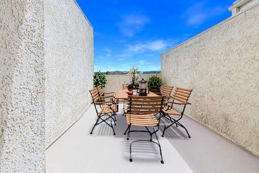 A table with chairs is set up on a balcony.
