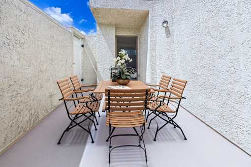 A table with chairs is set up on a patio.