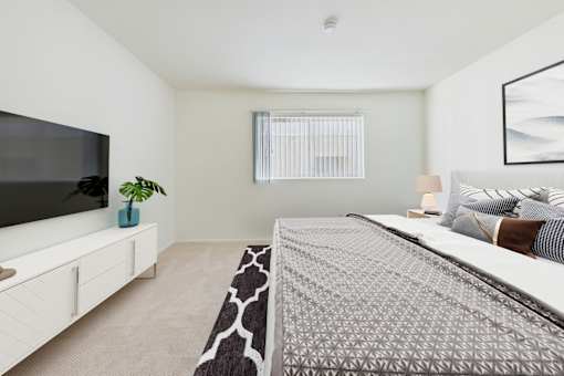 A bedroom with a large bed and a flat screen TV.