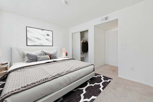 A bedroom with a large bed and a painting on the wall.