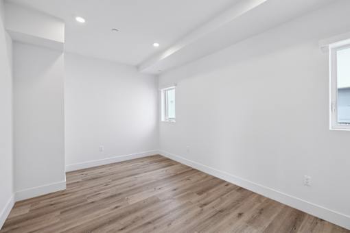 A room with wooden flooring and white walls.