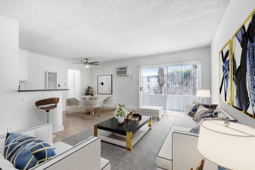 a living room with white furniture and a ceiling fan