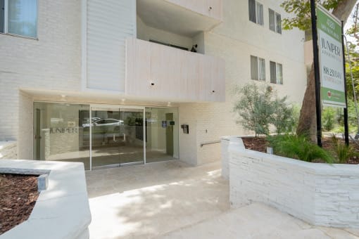 the entrance to a white building with a glass door
