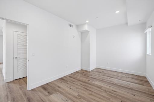 A room with wooden flooring and white walls.