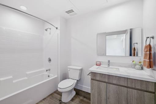 A white bathroom with a toilet, sink, and bathtub.