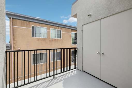 A balcony with a black railing and a white door.
