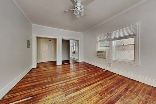 A room with wooden floors and a ceiling fan.