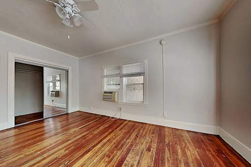 A room with a wooden floor and a ceiling fan.