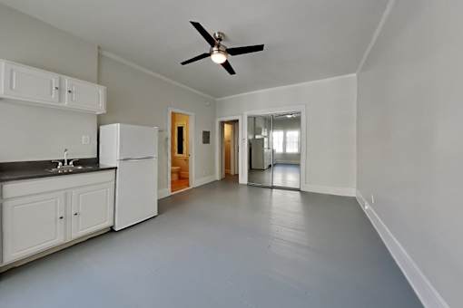 A spacious kitchen with white appliances and cabinets.