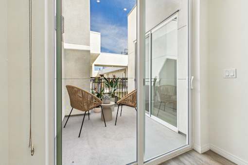 A patio with a table and chairs is visible through a glass door.