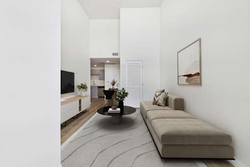 A living room with a grey rug, a brown sofa, and a coffee table.