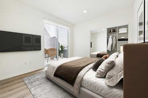 A bedroom with a large bed and a flat screen TV mounted on the wall.
