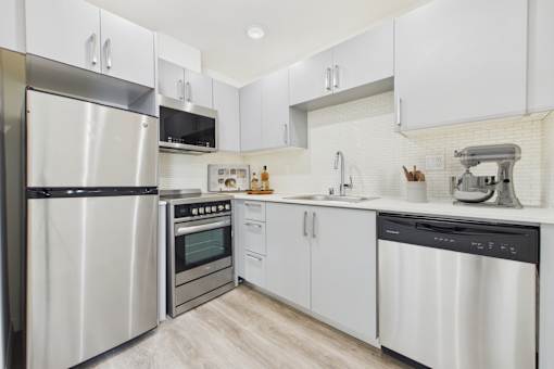 A modern kitchen with stainless steel appliances and white cabinets.