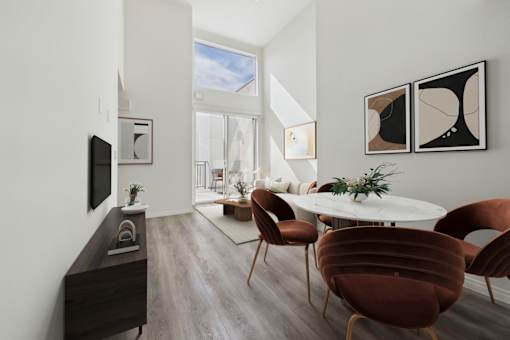 A modern dining room with a white table and brown chairs.