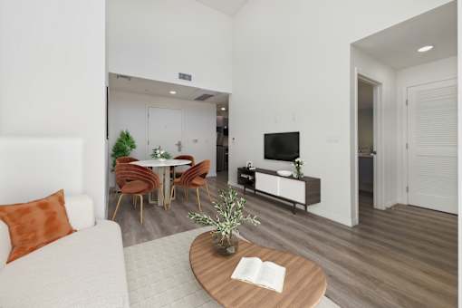 A living room with a white couch and a wooden coffee table.