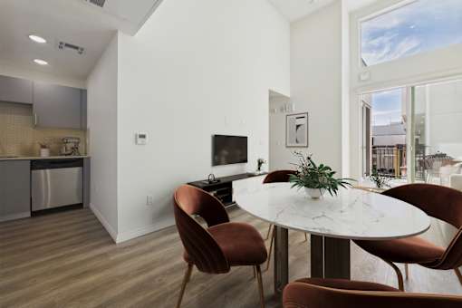 A modern dining room with a round table and chairs.