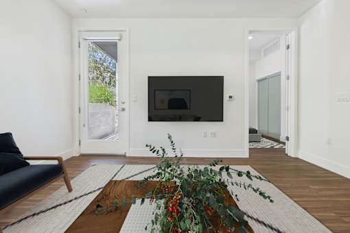 A living room with a black couch and a television.