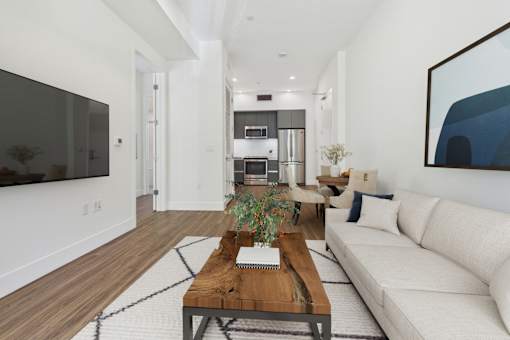 A modern living room with a white couch and a wooden coffee table.