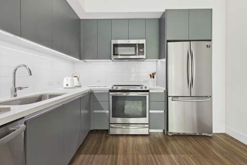 A modern kitchen with a stainless steel refrigerator and oven.