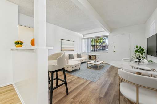 A living room with a white couch and a wooden floor.