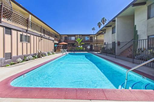 A swimming pool in a residential area with buildings on either side.