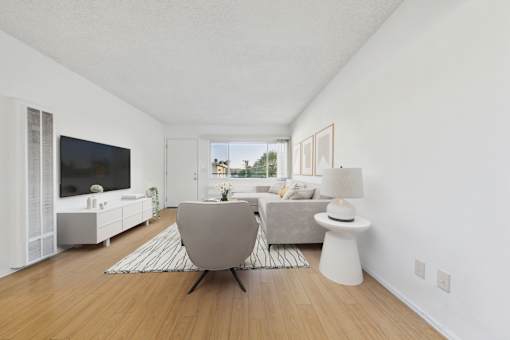 A modern living room with a grey chair and a white side table.