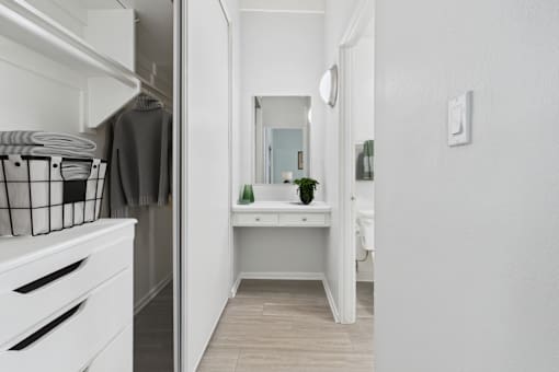 A white kitchen with a small table and a mirror.