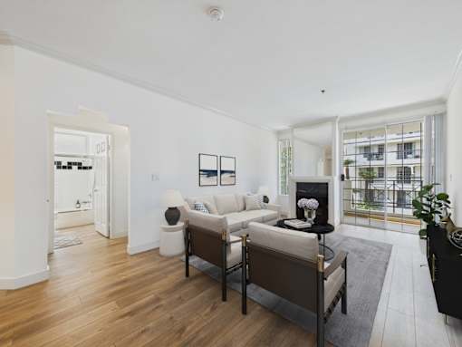 A living room with a white couch and a black chair.
