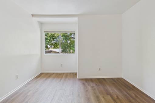 A room with wooden floors and a window.