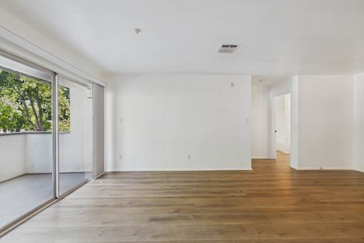 A spacious room with wooden floors and white walls.