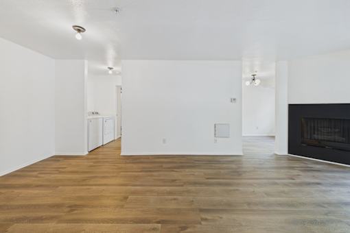A large empty room with wooden floors and white walls.