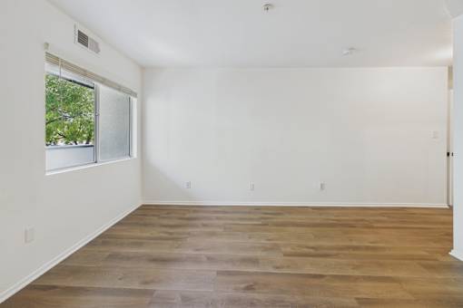 A room with wooden flooring and a window.